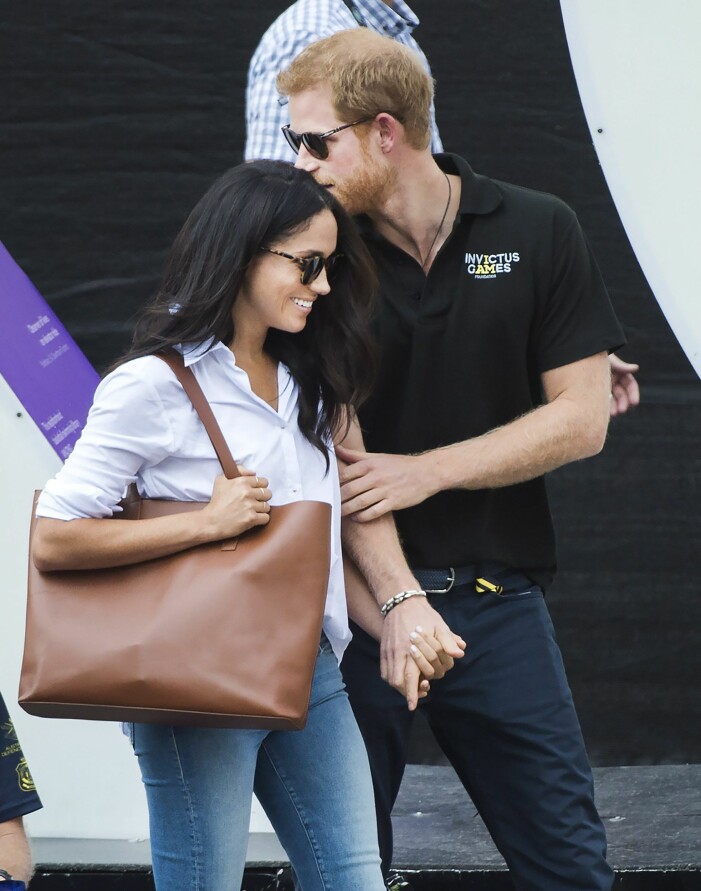 Meghan Markle med klassisk skinnväska från Cuyana. Foto: TT Meghan Markle i klassisk vit skjorta, jeans och solglasögon. På axeln bär hon en konjaksbrun handväska i tote-modell från Cuyana.