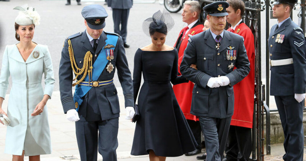 Extra vikt i klänningens bottensömmar förhindrar att plagget blåser upp. De brittiska prinsarna tillsammans med sina gemål Kate Middleton och Meghan Markle.