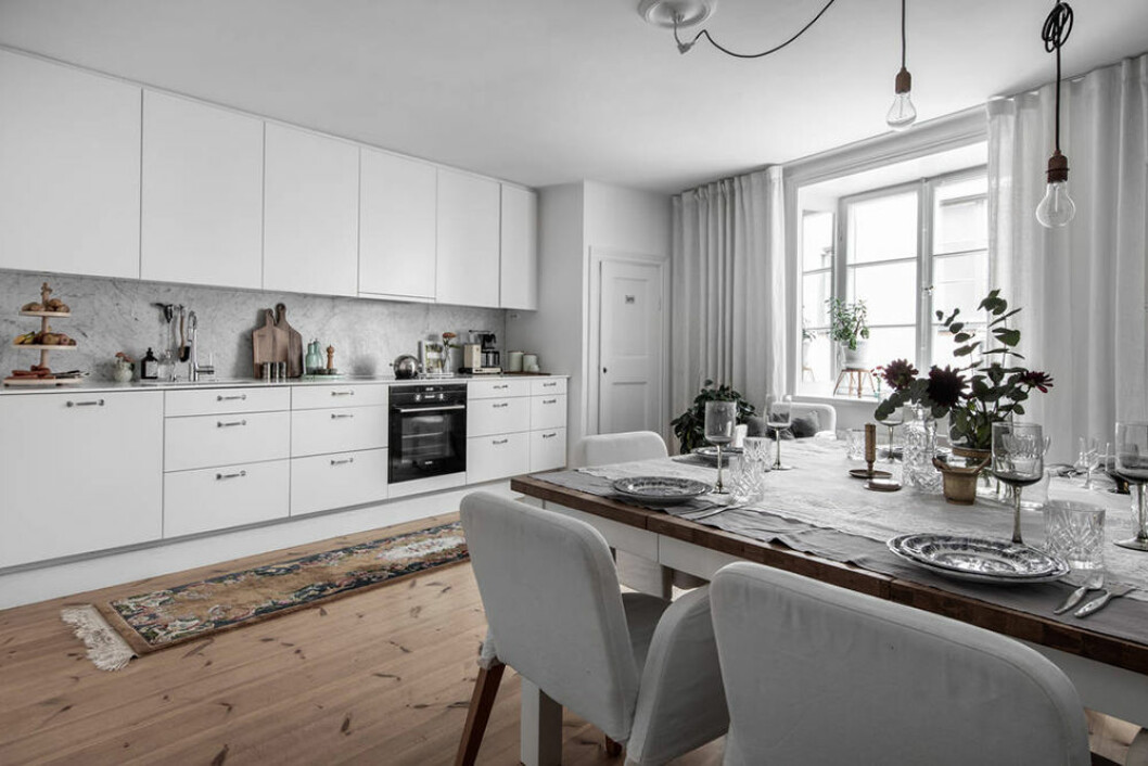 Köket är modernt och går i vitt. Modern kök i vitt och marmor i minihus på Södermalm
