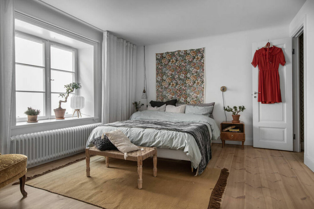 Ett av sovrummen är mycket rymligt och har fina spröjsade fönster. Mysigt sovrum i minihus på Södermalm