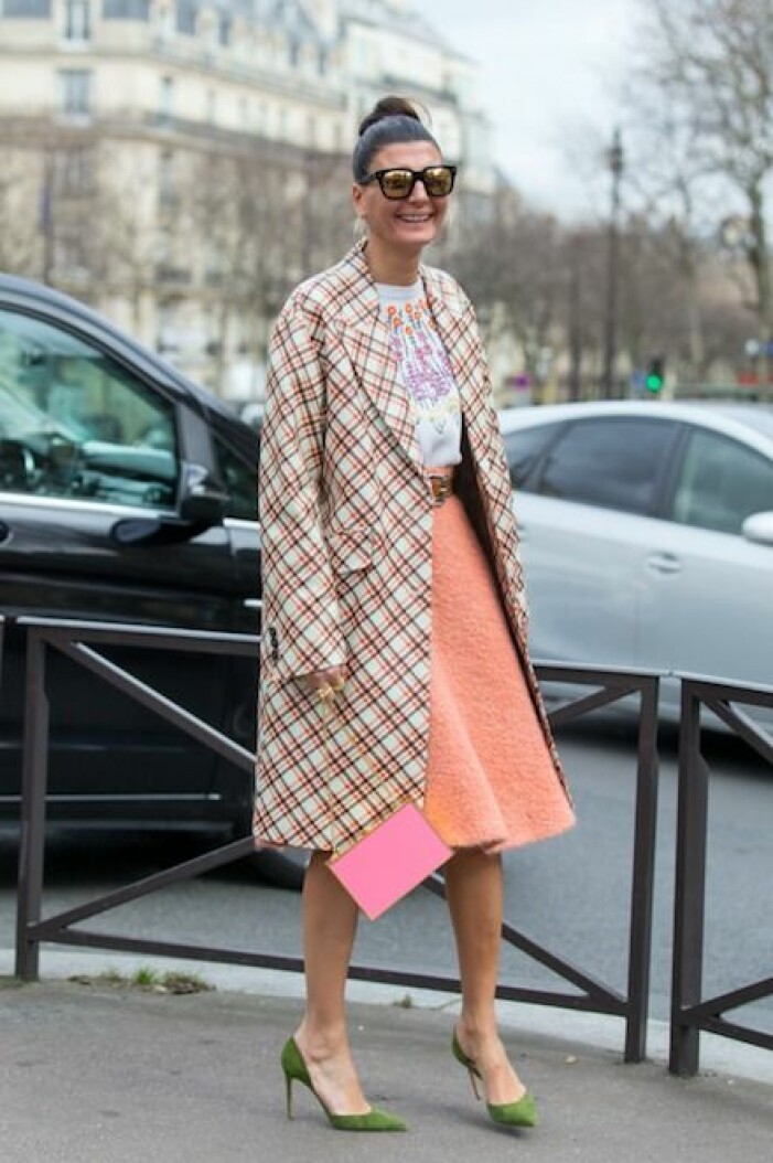 Giovanna Engelbert är inte rädd för att blanda färger, stilar och material. Giovanna Engelbert i färgglad och mönstrad outfit. Hon matchar en rosa kuvertväska med gröna pumps.