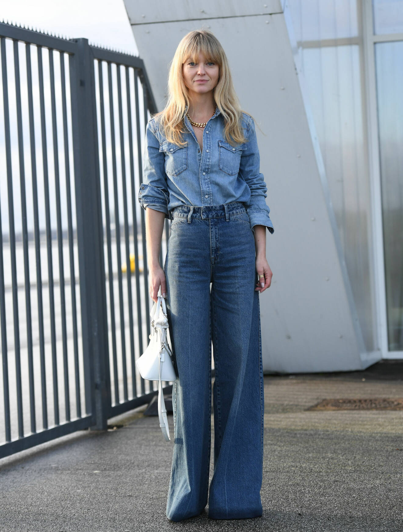 Influencern Jeanette Madsen bär vida jeans och jeansskjorta.