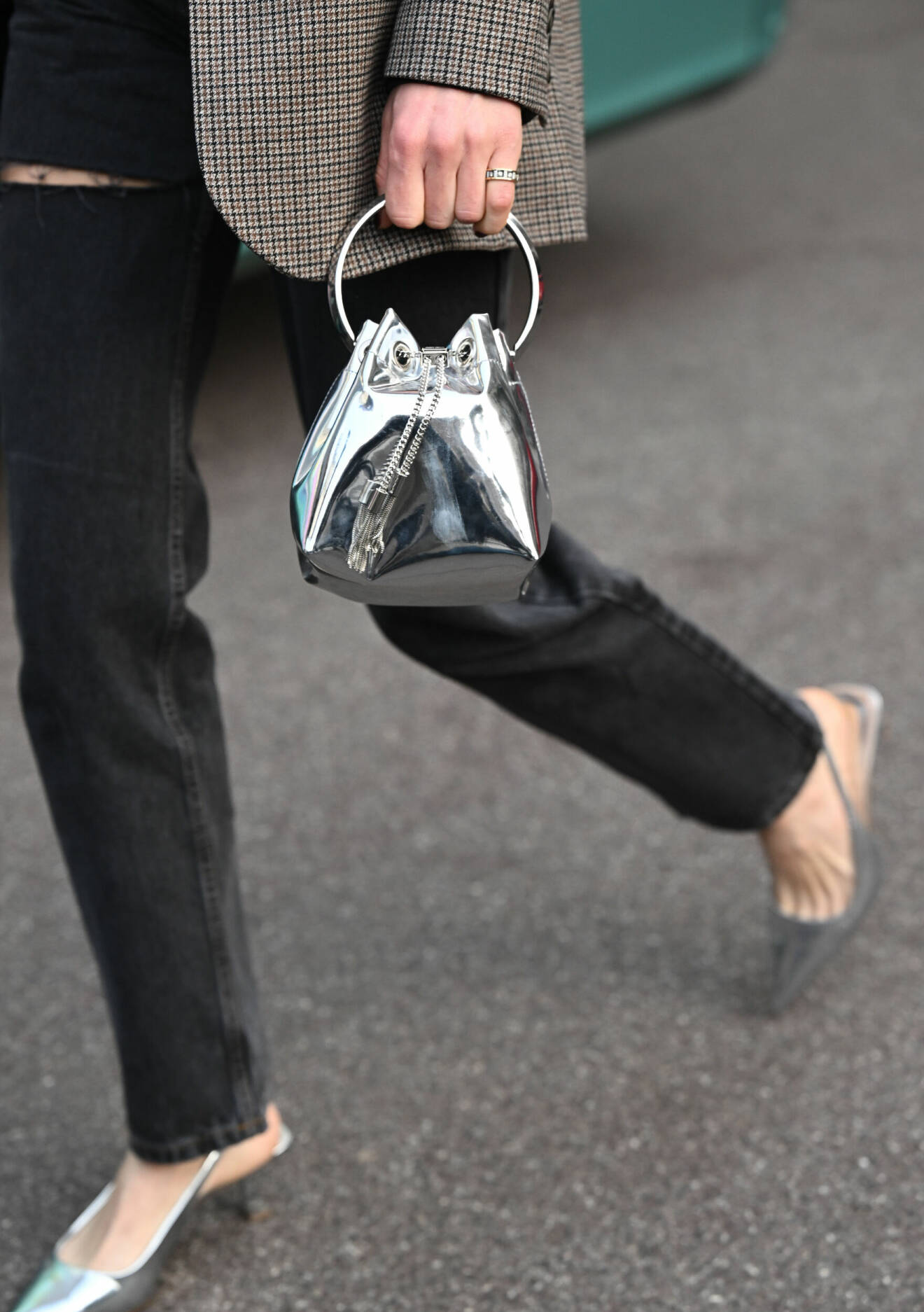 Gäst vid modeveckan i Milano bär silverfärgad väska och matchande pumps.