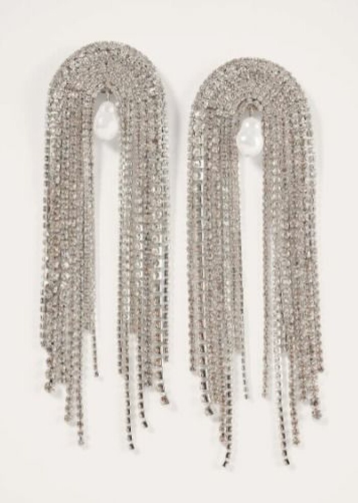 Örhängen, 149 kr, Nakd. <a target="_blank" rel="nofollow" href="https://clk.tradedoubler.com/click?p=270159&a=3025660&epi=an-statementaccessoarer&url=https%3A%2F%2Fwww.na-kd.com%2Fsv%2Fprodukter%2Forhangen-silver-2">Klicka på bilden för att komma direkt till produkten!</a> Oversizade strassörhängen formade som en båge. Hänger ner från öronen. En pärla i mitten under bågen. Flera rader med strass. Örhängen från Nakd.
