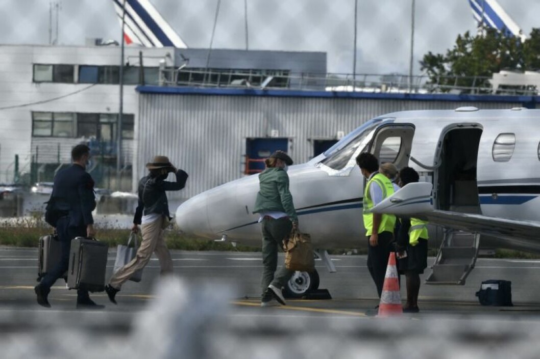 Här syns Nicole Poturalski och Brad Pitt kliva på flygplanet tillsammans. Brad Pitt i grön jacka och Nicole Poturalski strax bakom. Nicole Poturalski och brad pitt är på väg att kliva på ett flygplan