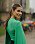Nina Sandbech klär i grön topp och stora guldörhängen.