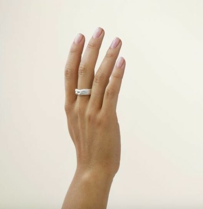 Ring, 1399 kr, Nootka jewlery. En hand med en bred, silverring med struktur på långfingret. Ring från Nootka jewlery.