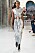Modell med midilång klänning i silverfärgade paljetter. Stor cutout vid magen och knytdetalj som hänger ned från bystet. Look från Paco Rabanne ss21.
