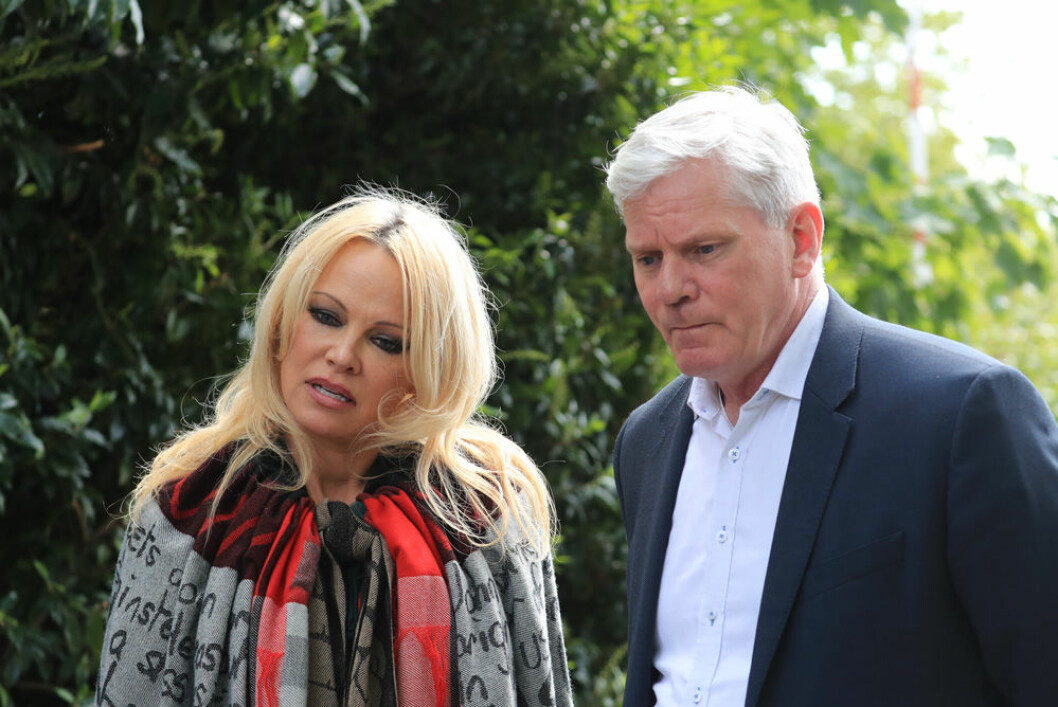 Pamela Anderson invirad i en filt med Assanges budskap på, tillsammans med en av Wikileaks-grundarna, på besök hos Assange i fängelset. Foto: TT Pamela Anderson tillsammans med en av Wikileaks-grundarna när de besökte Assange i fängelset.