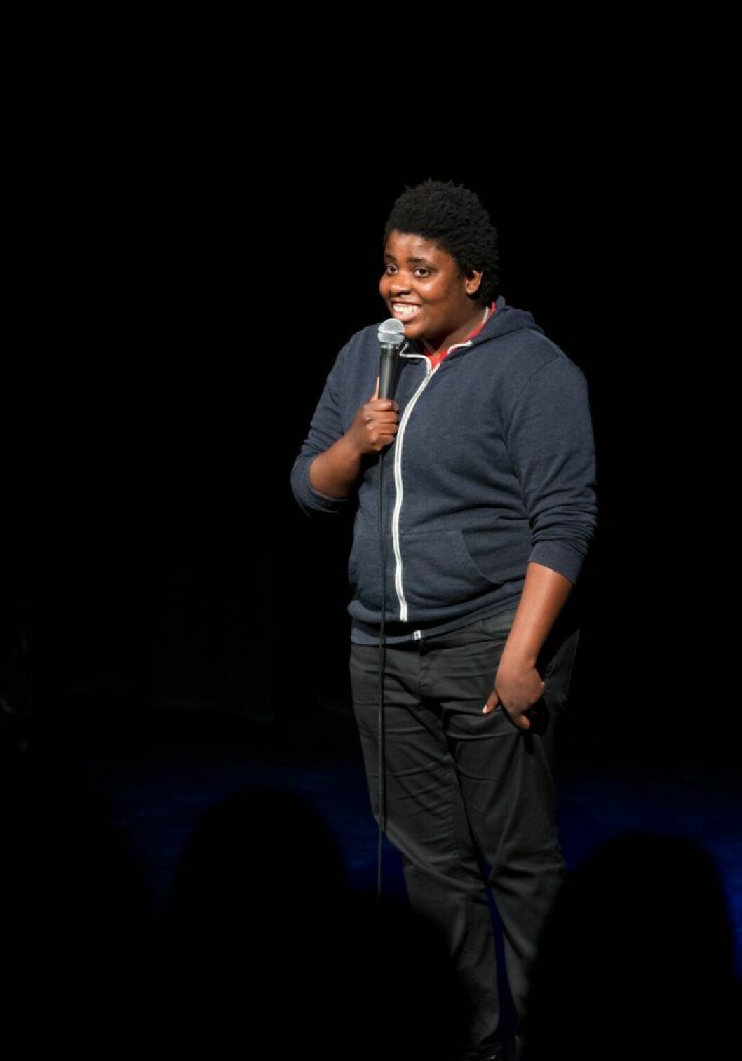 Petrina Solange är med och driver stand up-klubben Ståupp under jord. Petrina Solange står på scenen och heller i en mikrofon.