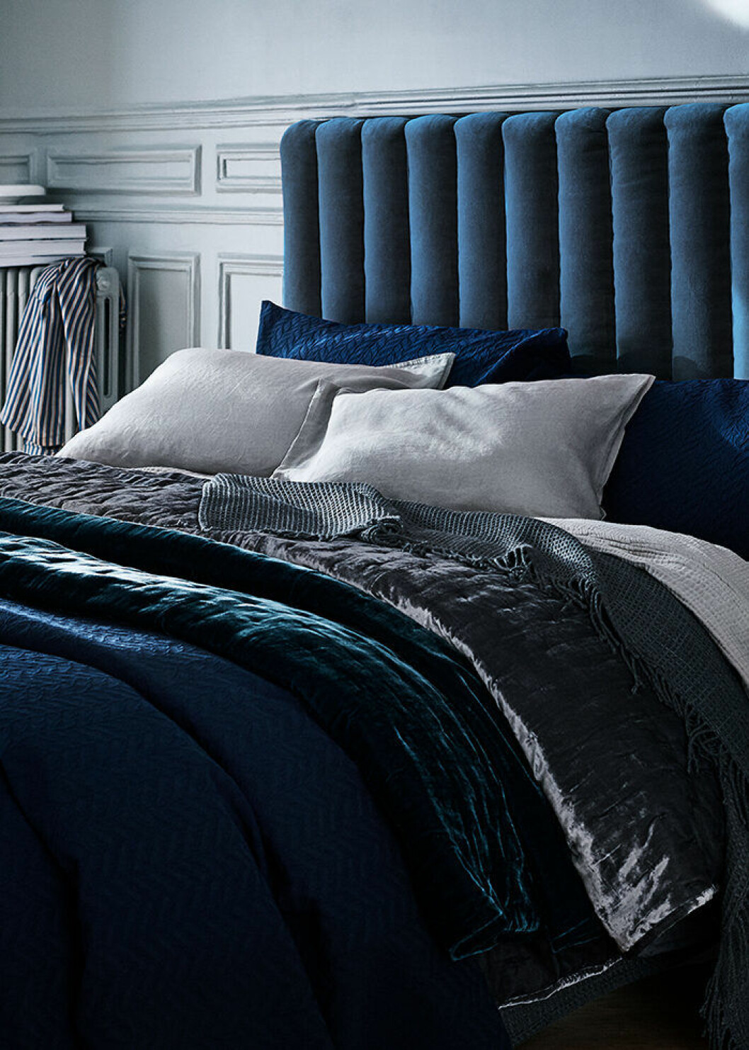 Ett petroleumfärgat överkast i sammet ger en fin touch till de i övrigt blå och grå tonerna. Foto: H&M Home Petroleumfärgat överkast i sammet från H&M Home