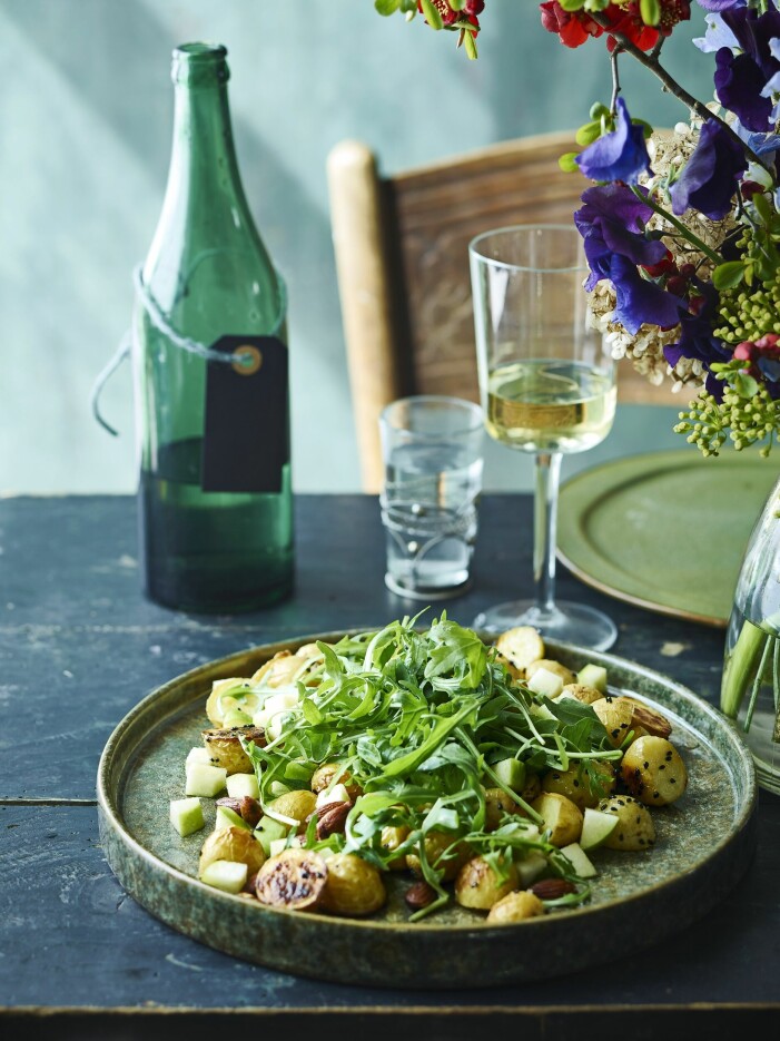 Rostad potatis blandas med krispiga äpplen, pepprig rucola och saltade mandlar. Potatissallad med äpple och rucola.