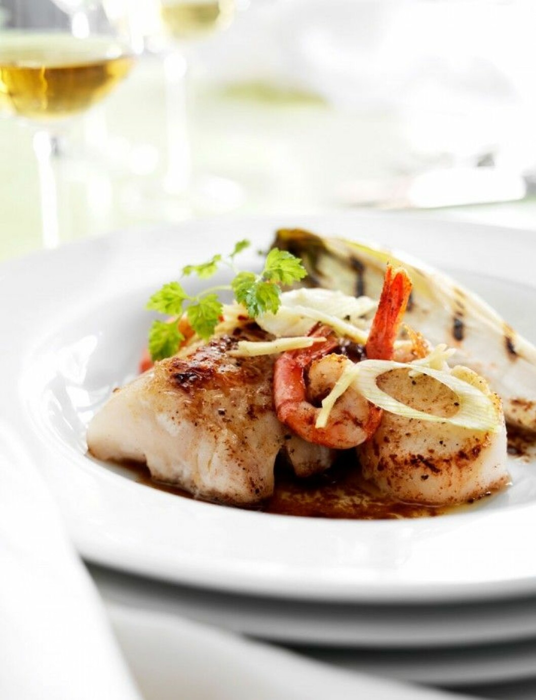 fisk- och skaldjurstallrik tillsammans med grillad endiv och brynt sojasmör.
