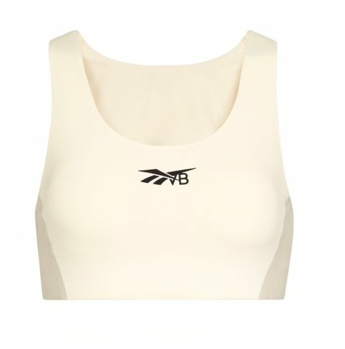 Topp, Adidas x Victoria Beckham. <a target="_blank" rel="nofollow" href="https://apprl.com/al/6rZd/">Klicka på bilden för att komma direkt till produkten!</a> Off-white sporttopp med svart logga mitt på bröstet. Sporttopp från Reeboks samarbete med Victoria Beckham.