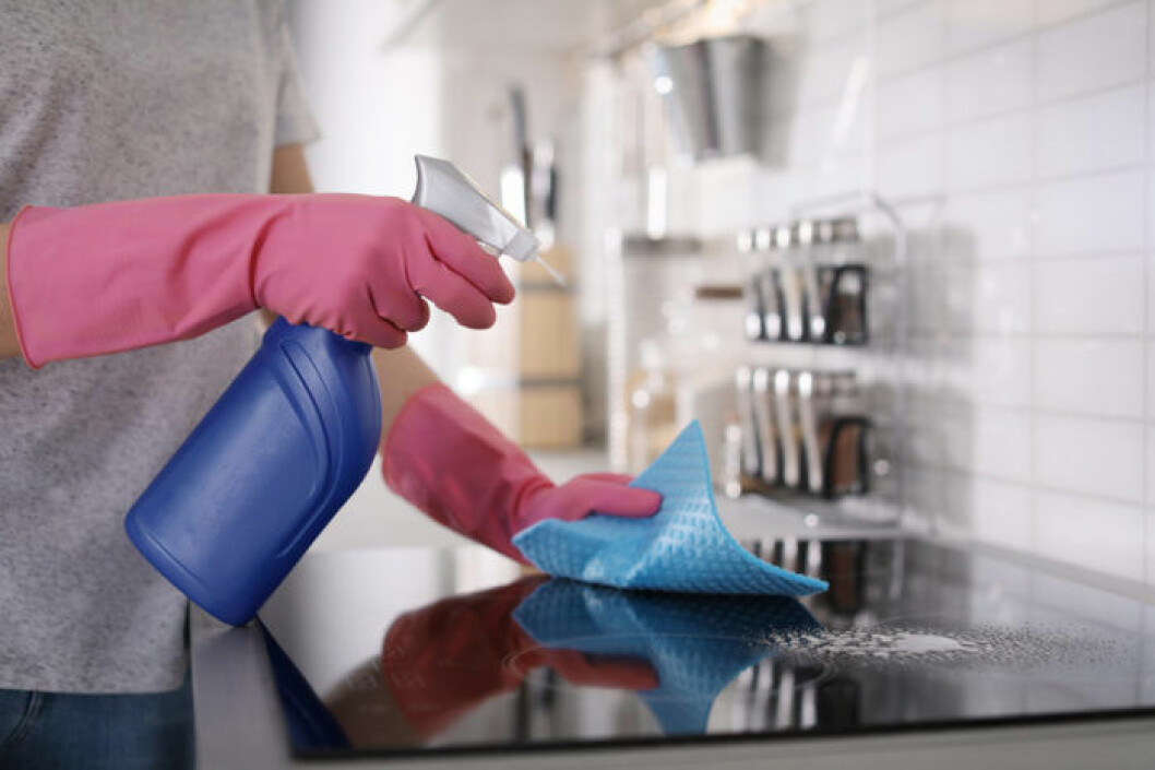 Bild: Shutterstock/IBL Kvinna med sprayflaska gör rent spishäll.