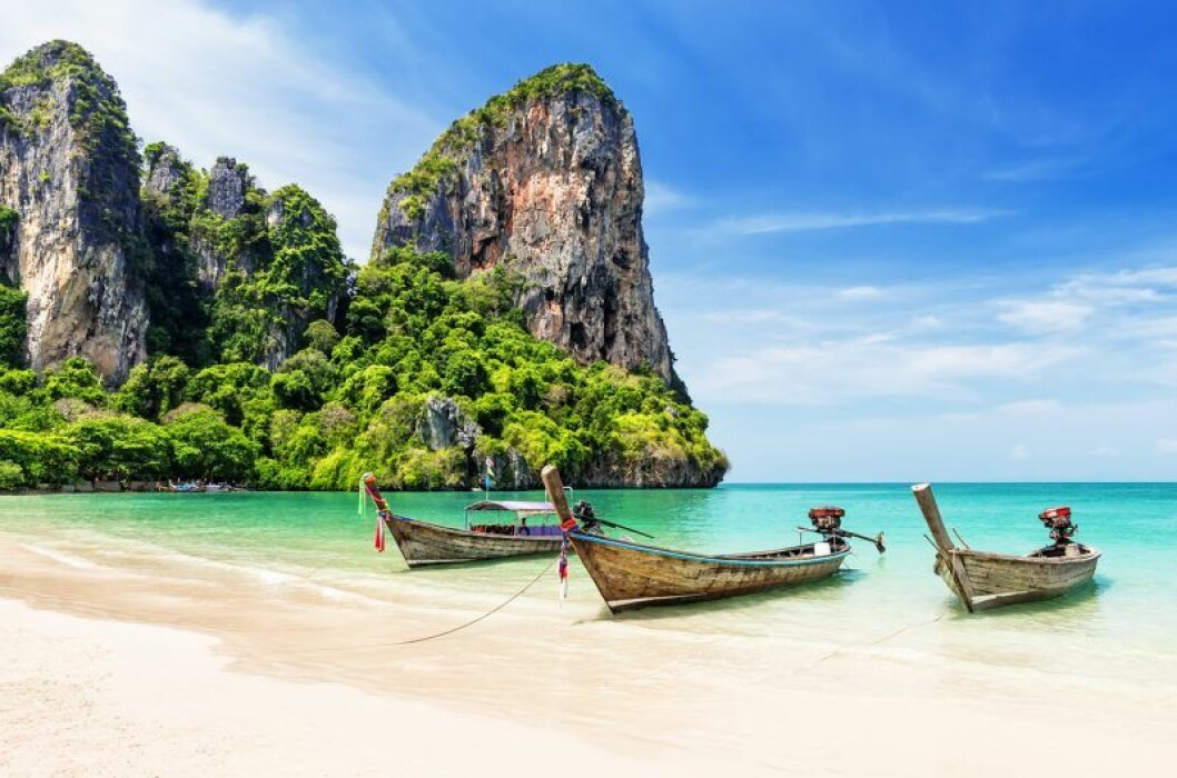 Thailändsk strand med longtailbåtar