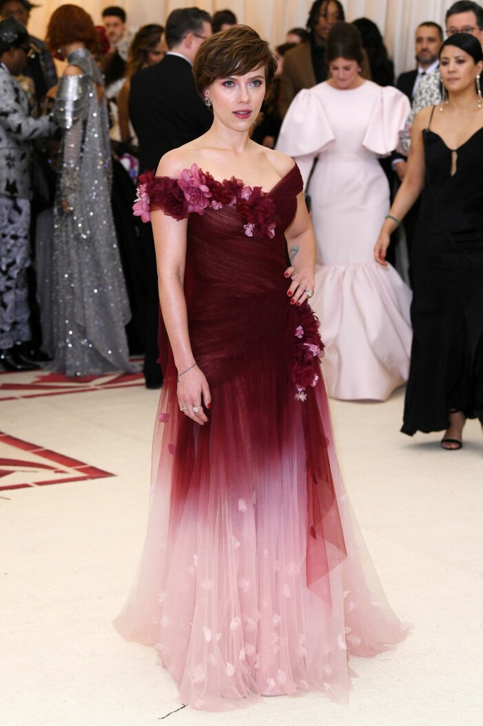 Scarlett Johansson valde en design av Harvey Weinsteins ex-fru på Met-galan 2018. Scarlett Johansson i vinröd och rosa klänning från Marchesa med blomdekorationer på Met-galan 2018.