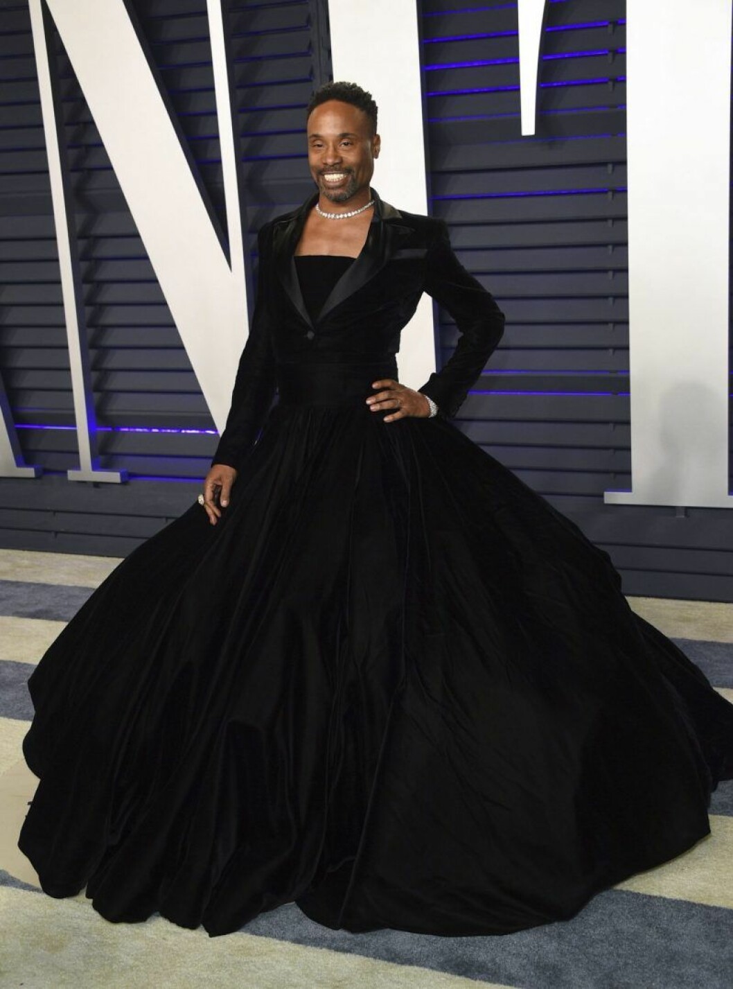 Billy Porter bryter normen. Billy Porter ler i en frack som kombineras med en klänning.