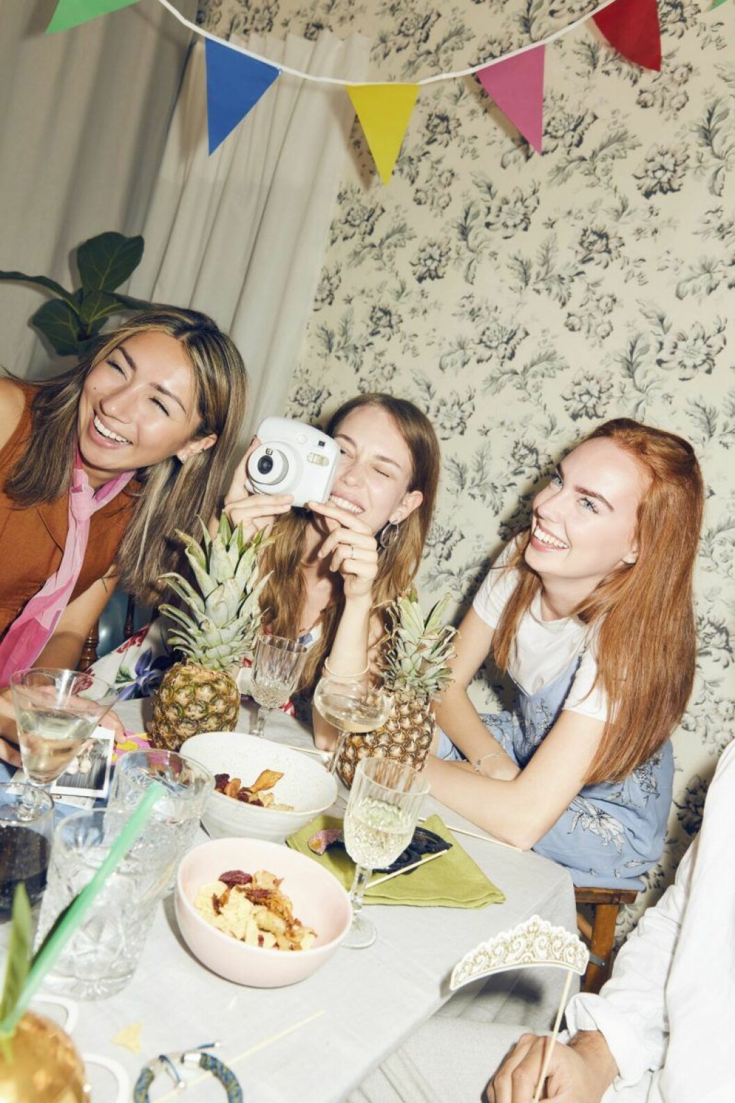Ställ fram polaroidkameror som gästerna kan använda under kvällen. Tjej fotograferar med polaroidkamera