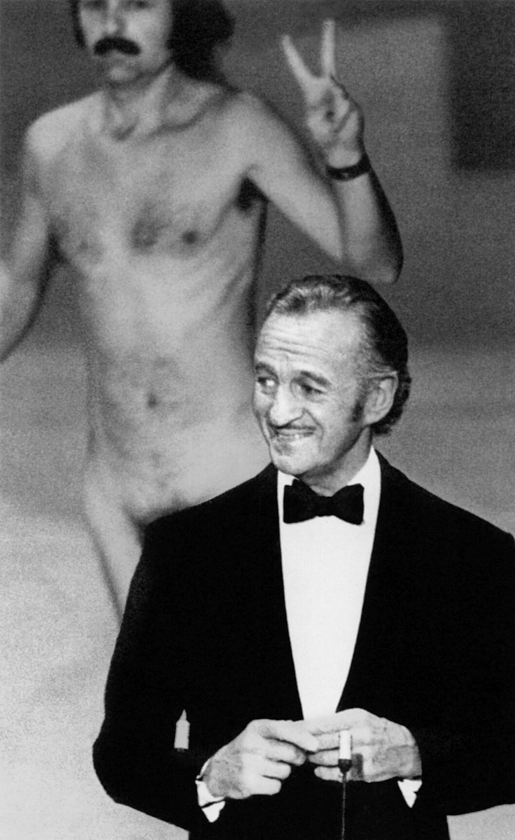 David Niven (t h) och Robert Opel delade scenen under den uppmärksammade nakenchocken vid <span class=" italic" data-lab-italic_desktop="italic">Oscarsgalan</span> 1974.