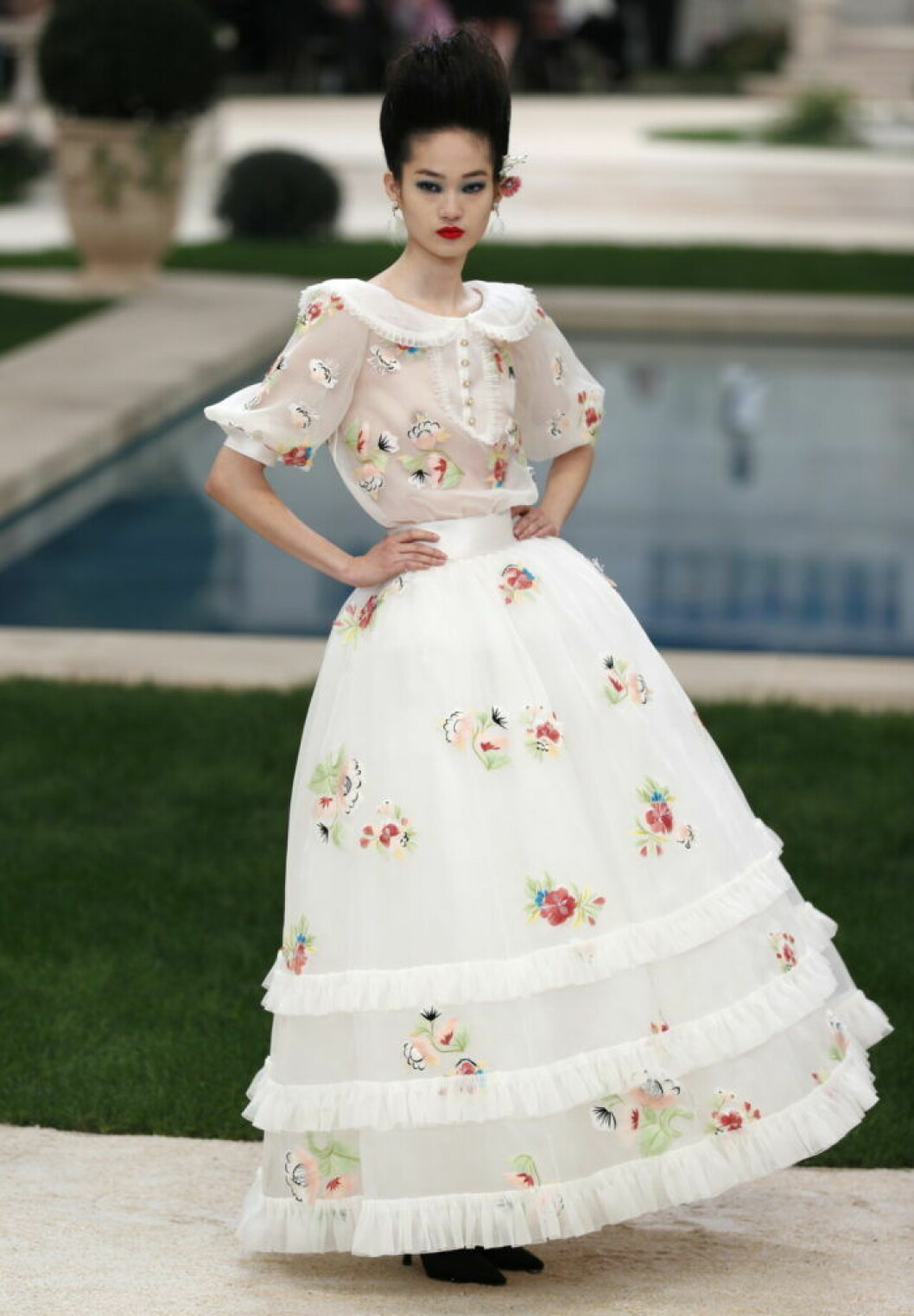 Karl Lagerfelds design under Chanelvisningen 2019, en vit sekelskiftesklänning med blommor.