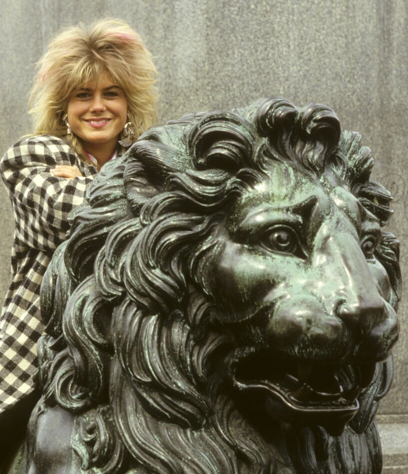 Exklusiv bild på två lejon fångad i samma bild. Pernilla Wahlgren i fluffig frilla på ett bronslejon.