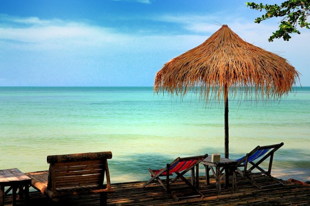 Sun chair under umbrella on a tropical sandy beach