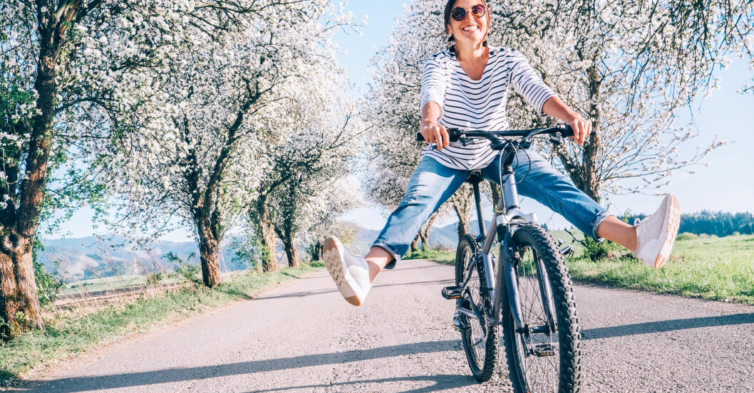 Glad kvinna på cykel