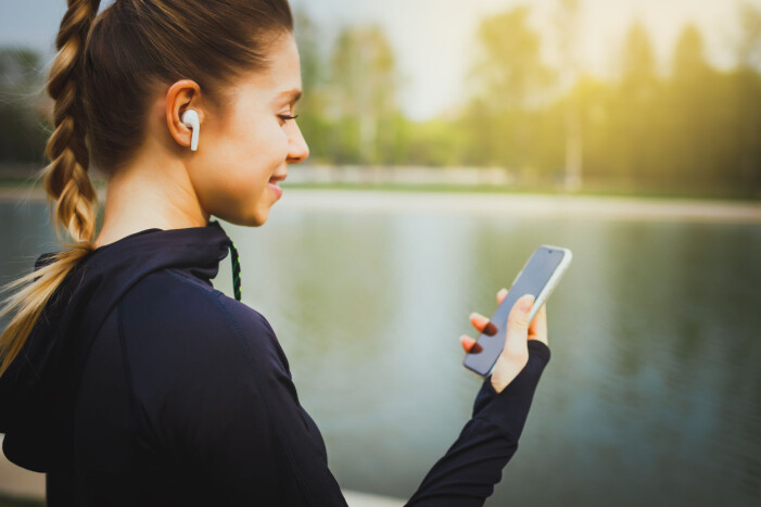 Om du använder dina AirPods ofta, eller använder dem när du tränar så kan vax, svett och smuts fastna. Kvinna tränar och lyssnar på AirPods