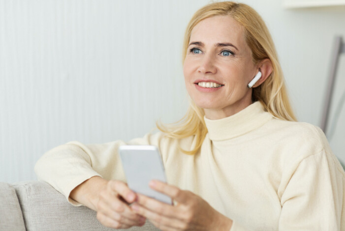 De flesta problemen med AirPods går enkelt att lösa själv hemma. Kvinna som pratar i sina AirPods