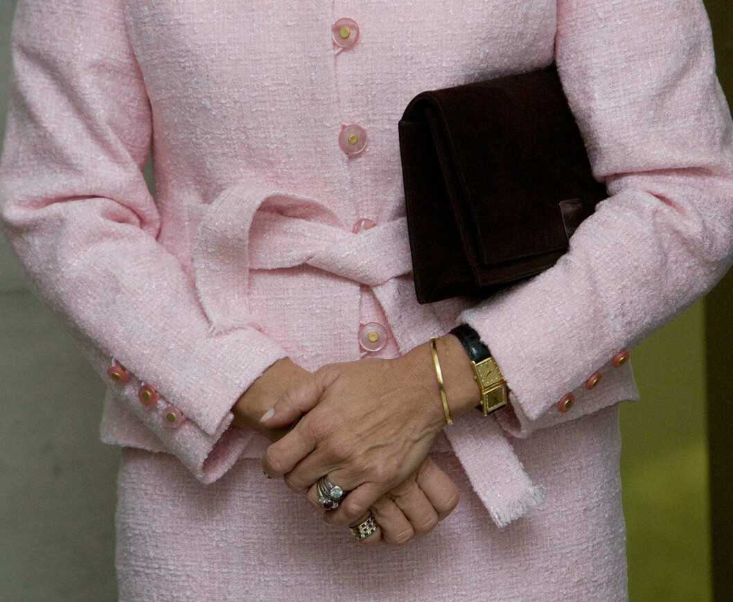 En klocka med dubbla urtavlor är lätt att matcha till dina andra smycken. Som här, där drottningen lagt till ett smalt guldarmband. Foto: Charles Hammarsten/IBL Drottning Silvia i rosa dräkt med klocka med dubbla urtavlor.
