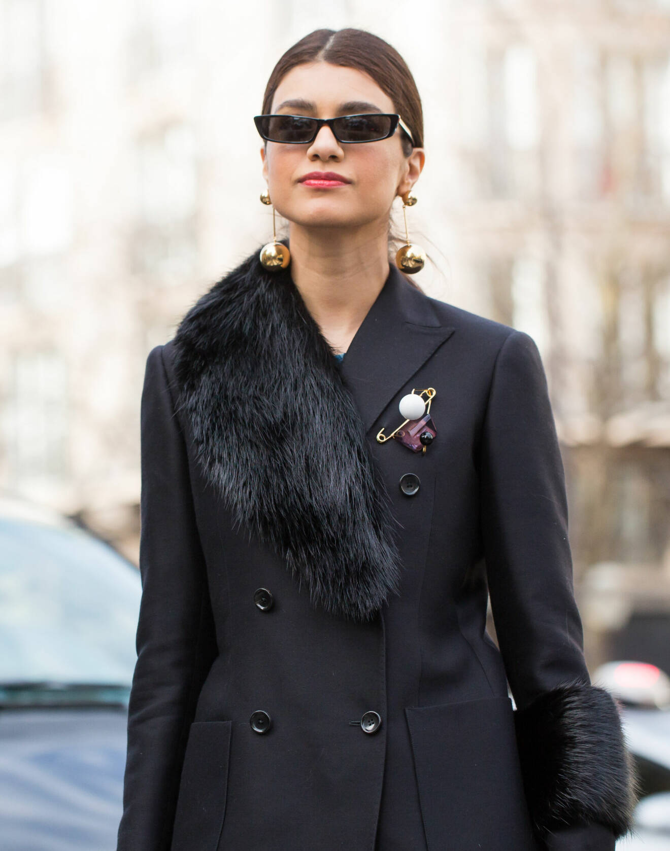 Trendig gäst på modeveckan i Paris iklädd svart kavaj och maffiga örhängen.