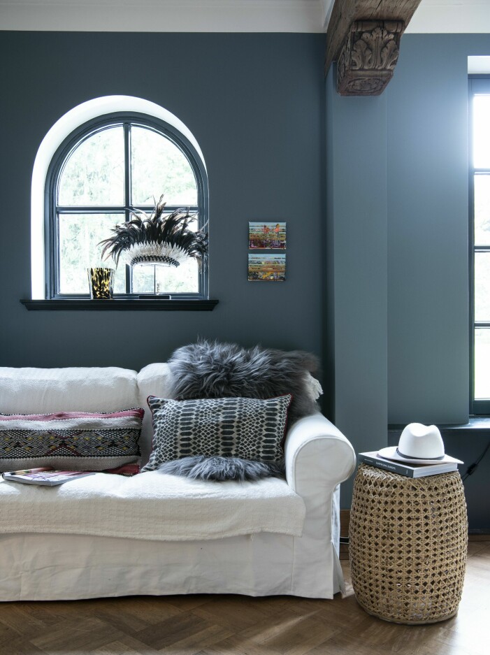 I den stora matsalen finns plats även för en soffa. Alla möbler från Annemarie Povels inredningsföretag, Wow Interiors. Soffa framför blå vägg.