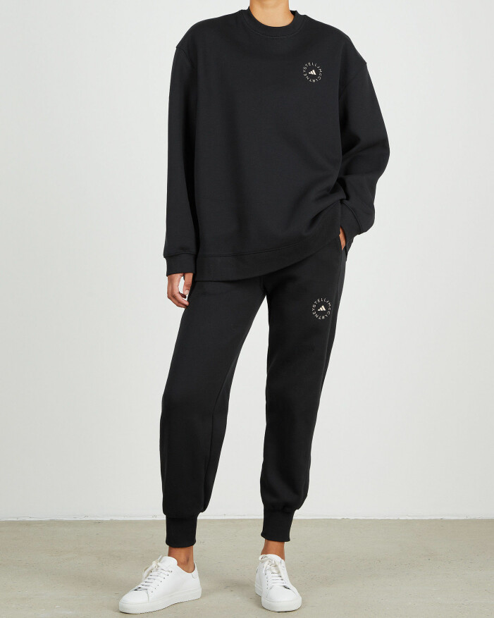 Sweatshirt och sweatpants, Adidas by Stella McCartney. <a target="_blank" rel="nofollow" href="https://at.wakakuu.com/t/t?a=1241227584&as=1218462148&t=2&tk=1&epi=an-traningsset&url=https://www.wakakuu.com/se/dam/klader/traningsklader/adidas-by-stella-mccartney-byxa-asmc-sc.html">Klicka på bilden för att komma direkt till produkterna!</a> Modell med svart swetshirt och svarta sweatpants. Set från Adidas by Stella McCartney.
