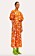 Modell med en maxiklänning i orange siden med ljusrosa blommor på. Klänningen har puffärmar och markerad midja. Klänningen är stylad med gröna boots i metallic. Klänning från Stine Goya.