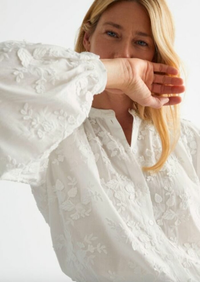 Blus, & other stories. <a target="_blank" rel="nofollow" href="https://track.adtraction.com/t/t?a=1279077969&as=1218462148&t=2&tk=1&epi=an-blommigt&url=https://www.stories.com/en_sek/clothing/blouses-shirts/blouses/product.printed-collarless-button-up-blouse-white.0954744002.html">Klicka på bilden för att komma direkt till produkten!</a> Modell med vit blus med blombroderier på. Blus från And other stories.