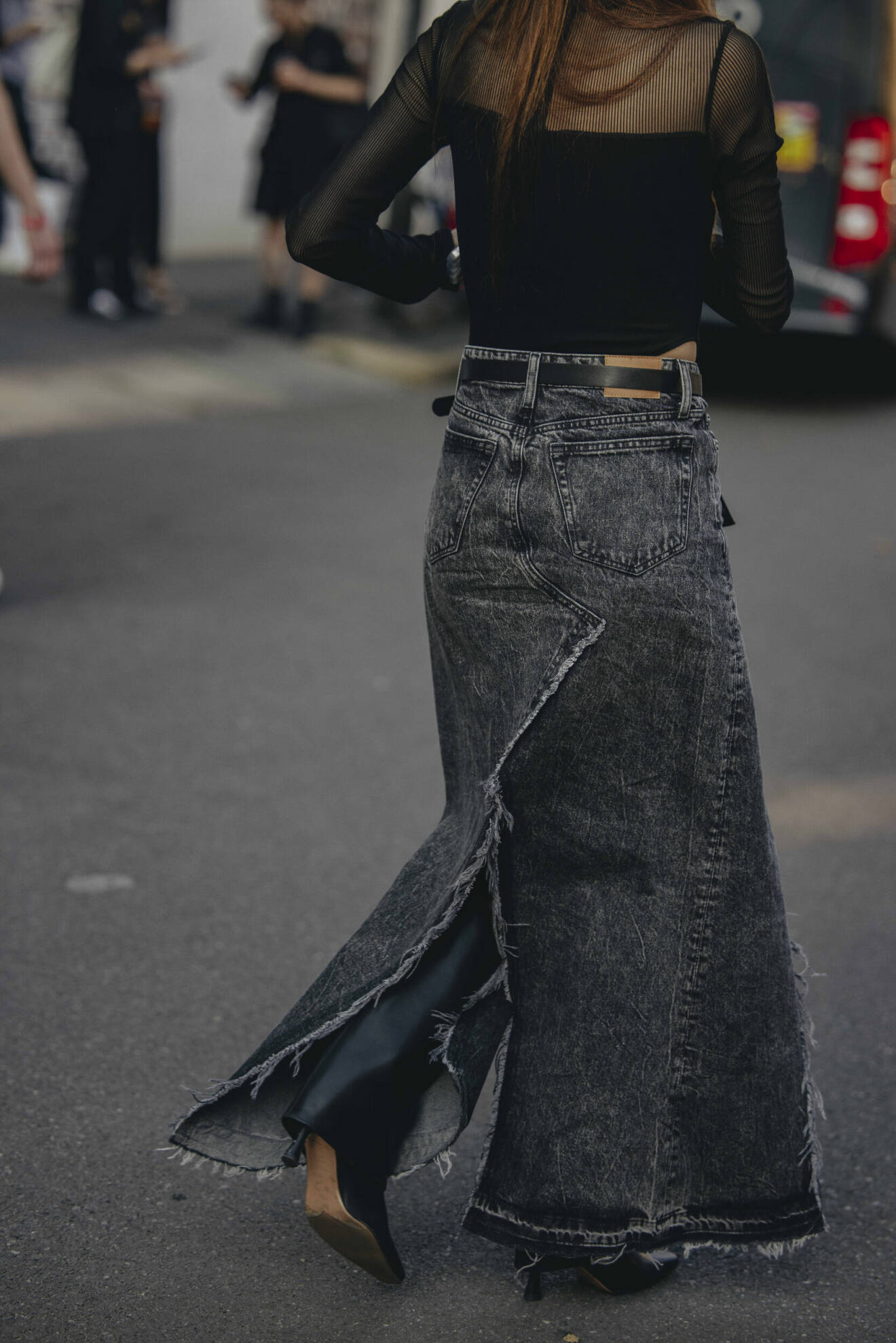 Streetstyle-outfit med en lång grå jeanskjol och höga stövlar.