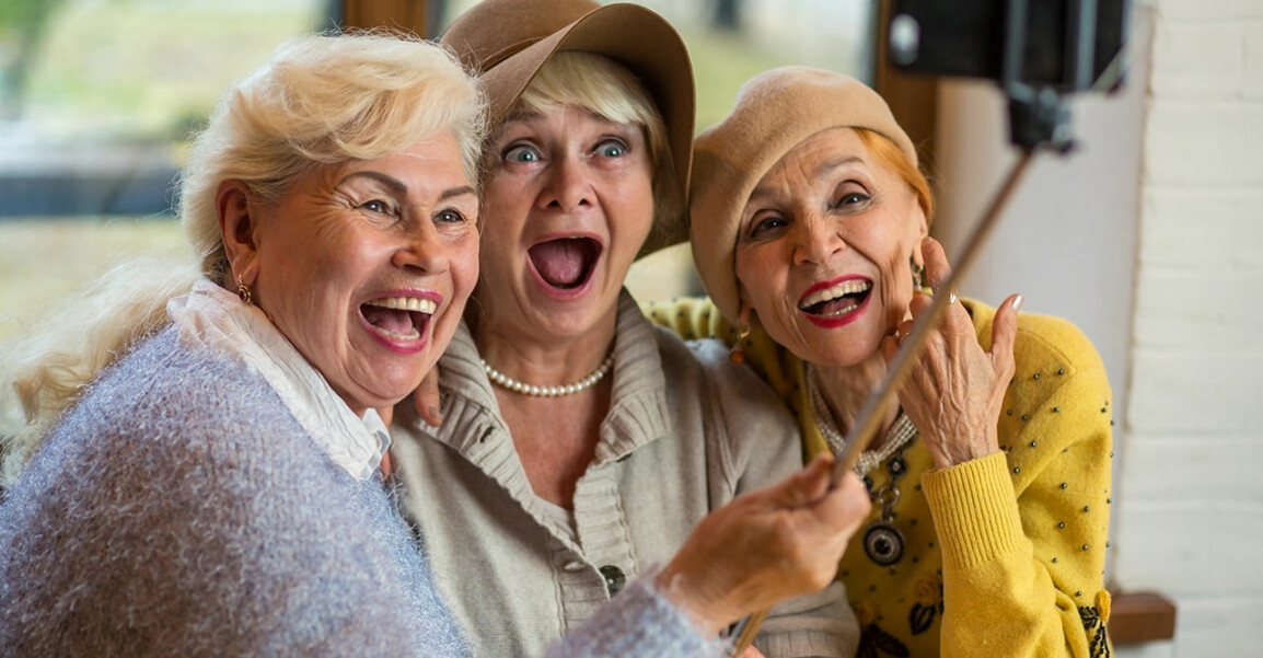Tre glada tanter ler mot en mobilkamera