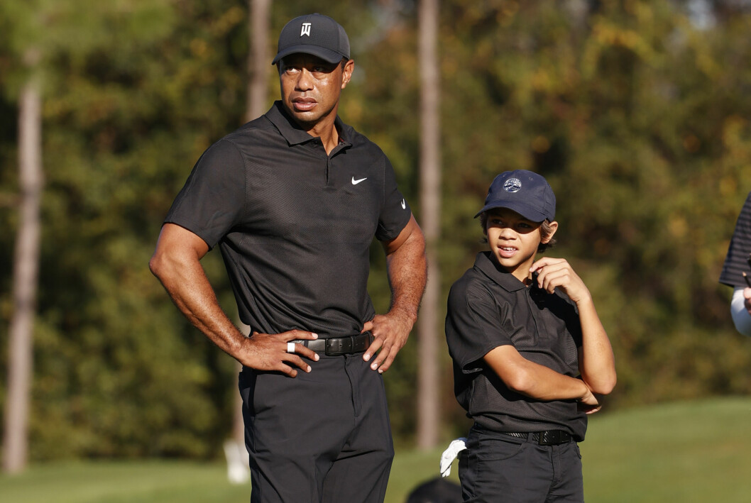 Far och son Tiger och Charlie Woods matchar i svart och keps. tiger och charlie woods på golfbanan