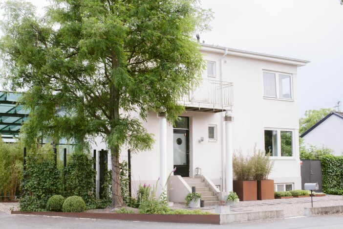 Charlottas och Pers läckra funkishus i Lomma är från 1939 och renoverat på 90-talet. Framsidan hålls ganska formell för att bryta med den gröna trädgården som döljs bakom. Trädgården i Lomma huset från framsidan funkis