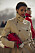 En klassisk beige trenchcoat snyggt matchad med röd väska och rött läppstift.