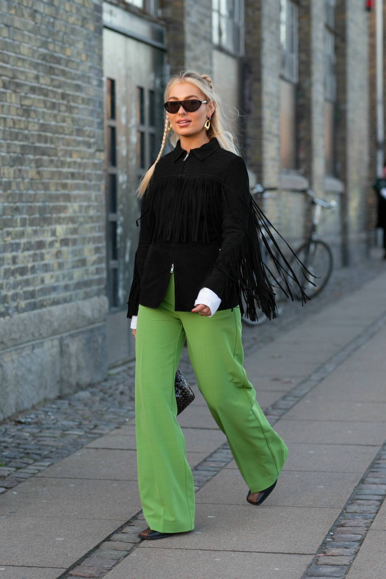 Vida gröna byxor matchad med svart fransjacka på modeveckan i Köpenhamn.
