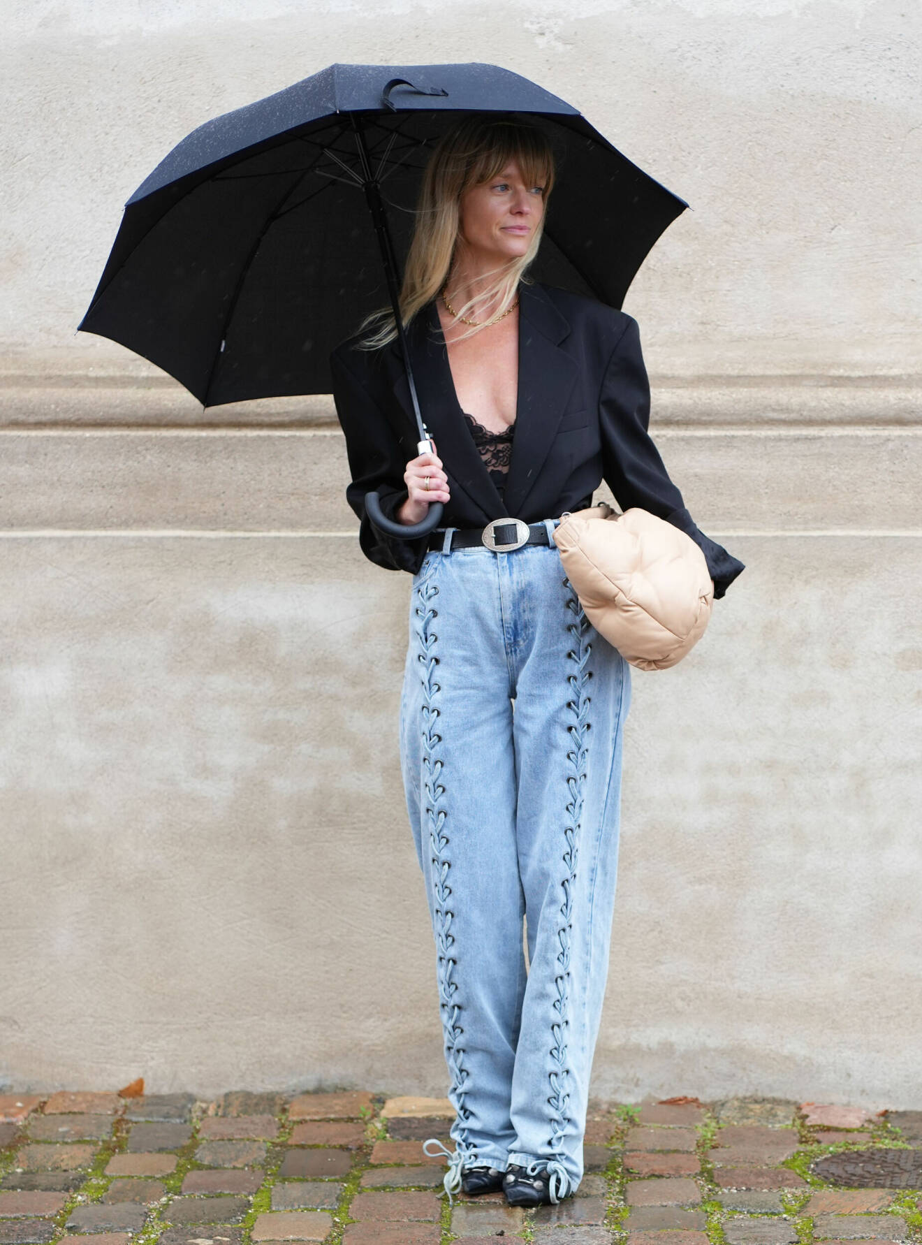 Jeanette Madsen iklädd jeans i vid modell med dekorativ snörning.