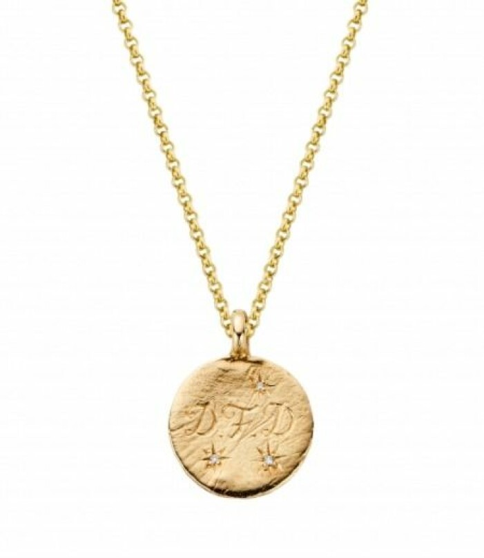 Halsbandet som Kate bar under sitt Twitter-klipp. Halsband från Daniella Draper. Guldhalsband med tunn kedja och rund berlock med inristade bokstäver på. Berlockhalsband från Daniella Draper.