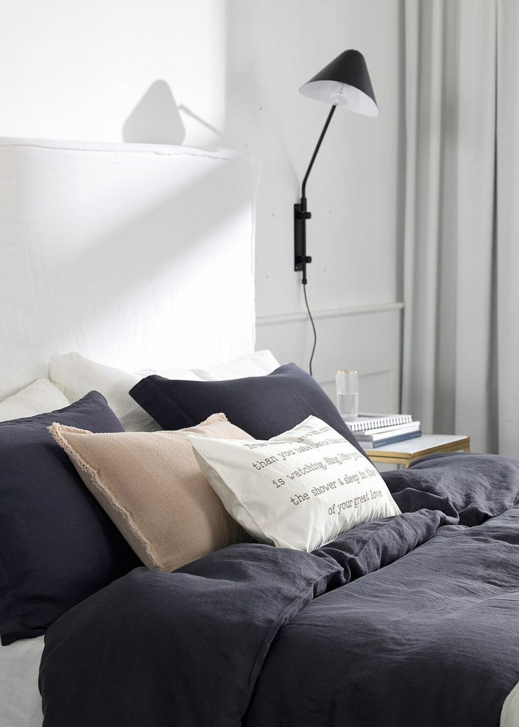 Sovrum med vägghängd svart lampa