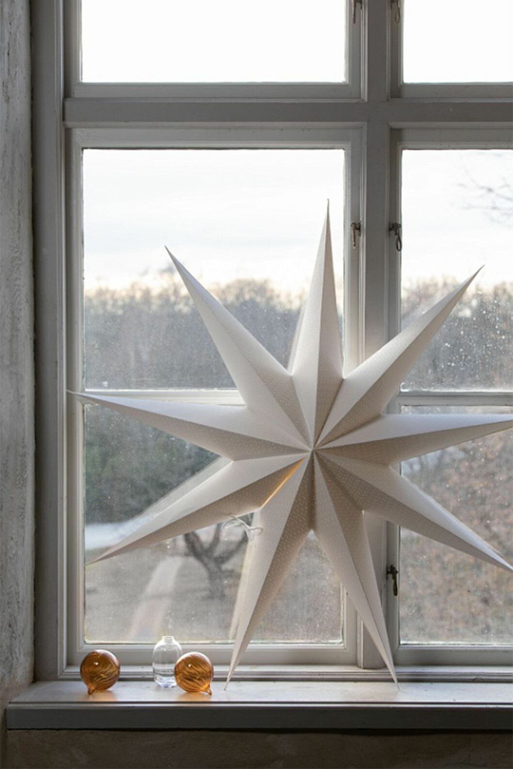 Julstjärnan behöver inte kompletteras med ljus eller ens hängas upp. Foto: Watt & Veke Vit julstjärna i fönster, från Watt & Veke