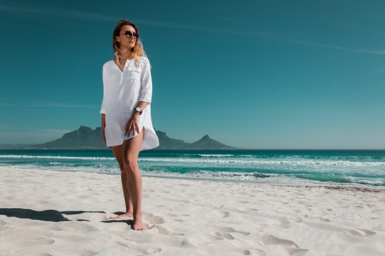 kvinna med solglasögon och bara ben på stranden