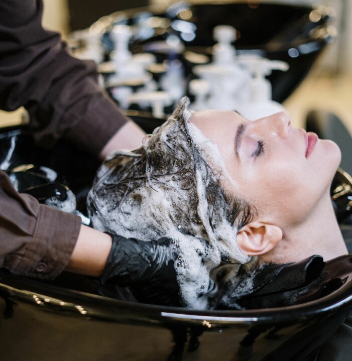 kvinna som får håret tvättat och masserat