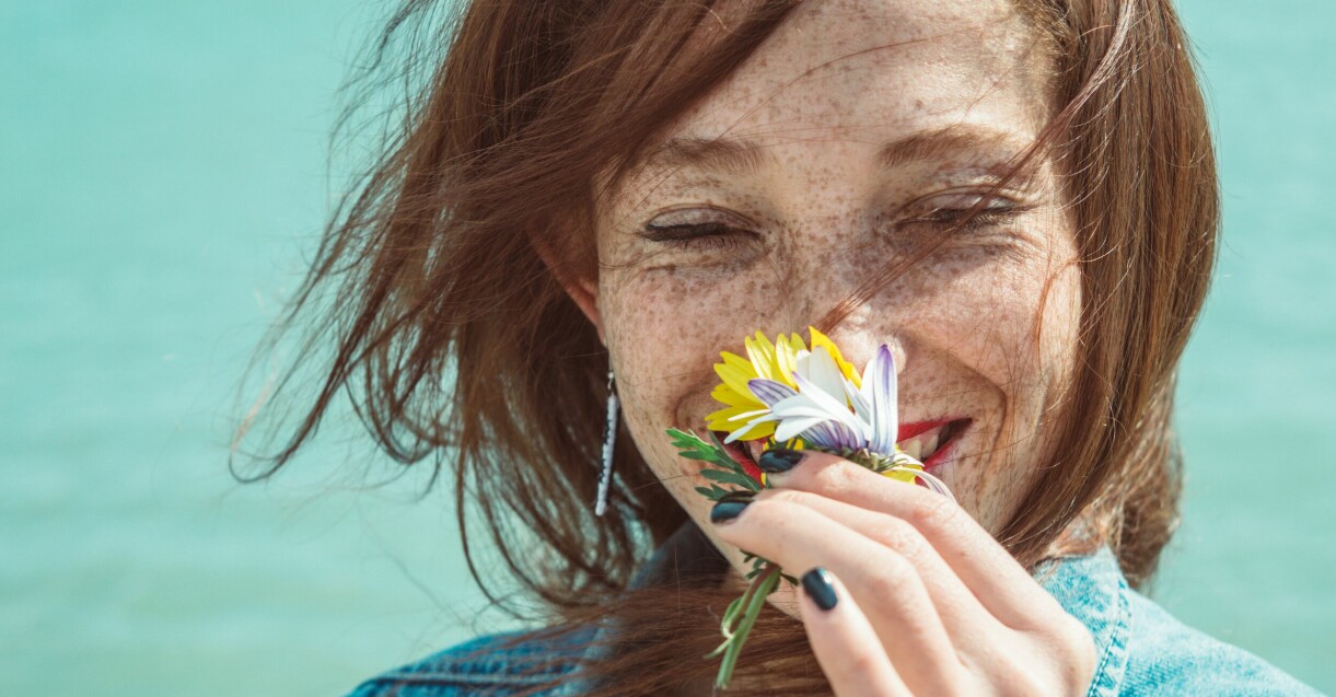 fräkning kvinna som doftar på blommor