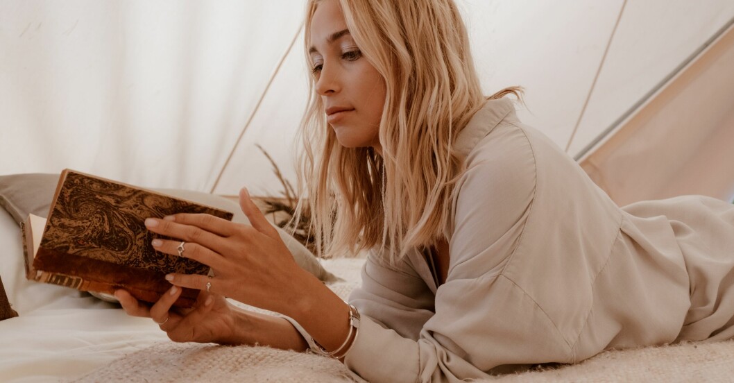 kvinna med vågigt hår som läser en bok